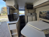 Dînette et table de l’Adria Twin Plus vues depuis la porte coulissante