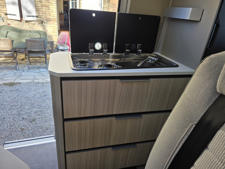 Cuisine avec plaque de cuisson et rangements de l’Adria Twin Plus