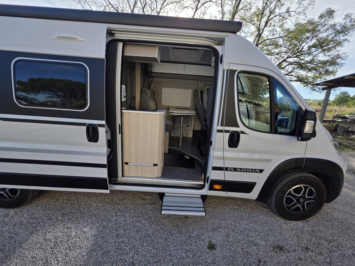 Porte coulissante ouverte sur l’espace de vie de l’Adria Twin Plus