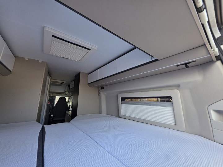 Couchage arrière sous les rangements hauts de l’Adria Twin Plus